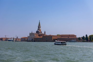 Venedik, İtalya, 11 Ağustos 2025, San Giorgio Maggiore adası, kilise ve su otobüsü. İtalya, Venedik 'teki adasında San Giorgio Maggiore Kilisesi' nin ön planda bir su otobüsüyle gezintisi..