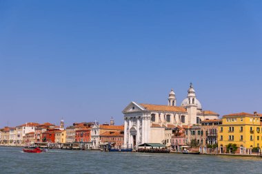 Venedik, İtalya, 11 Ağustos 2025: Gesuati kilisesi ile renkli Venedik kanalı. Venedik, İtalya 'da Santa Maria del Rosario Gesuati Kilisesi ve açık bir yaz gökyüzünün altında canlı kanal binaları..