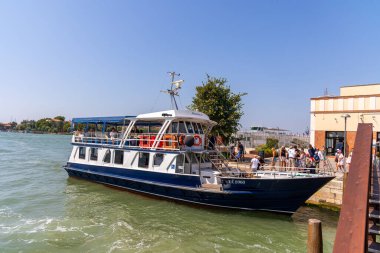 Venedik, İtalya, 11 Ağustos 2025 Venedik Adası rıhtımına yanaştı. Venedik adasında güneşli bir rıhtıma yanaşan bir yolcu teknesi. Turistler yaz gününün tadını çıkarıyor..