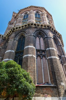 Venedik, İtalya, 11 Ağustos 2025: Venedik, İtalya 'daki Gotik Tuğla Kilisesi Cephesi. Venedik 'te Gotik tarzı tarihi bir tuğla kilisenin alçak açılı görüntüsü, uzun kemerli pencereler ve temiz bir gökyüzü altında dekoratif taş işçiliğine sahip..