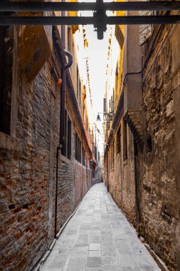 Eski tuğla binalar arasında dar bir ara sokak. Eski tuğla ve taş duvarlarla kaplı ıssız dar bir sokakta sakin bir Avrupa şehrinde tarihi kent mimarisi sergileniyor.