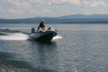 Motorlu tekne deniz yüzeyinde hızla yüzer.
