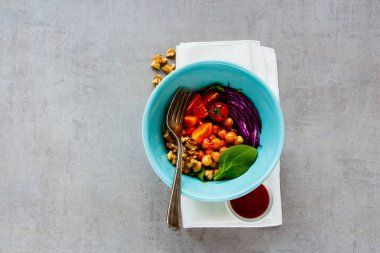 Healthy vegan buddha bowl with chickpeas, spinach, tomatoes, red cabbage, walnuts and honey dressing on light background. Diet, dieting concept. Vegan food, healthy eating. Top view, flat lay clipart