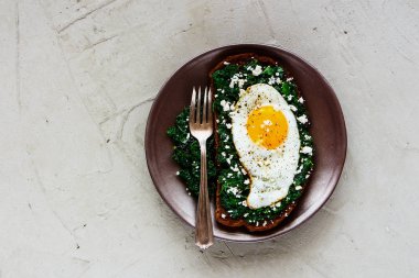 Kale, kızarmış yumurta ve beton arka plan üstten görünüm üzerinde beyaz peynir ile ev yapımı kahvaltı çavdar ekmeği sandviç. Sağlıklı yeme, zayıflama, diyet yaşam tarzı konsepti. Düz yatıyordu stili.