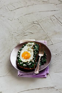 Tabak kızarmış yumurtalı sandviç çavdar ekmeği ile beton arka plan yan görünüm üzerinde kale ve beyaz peynir. Sağlıklı yeme, zayıflama, diyet yaşam tarzı konsepti. Vejetaryen kahvaltı