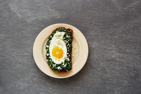 Sabah kahvaltı çavdar ekmeği sandviç plaka kale, kızarmış yumurta ve beton arka plan üstten görünüm üzerinde beyaz peynir ile. Sağlıklı yeme, zayıflama, diyet yaşam tarzı konsepti. Düz yatıyordu stili.