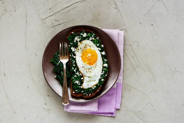 Kale, kızarmış yumurta ve beton arka plan üstten görünüm üzerinde beyaz peynir ile taze çavdar ekmeği sandviç. Sağlıklı yeme, zayıflama, diyet yaşam tarzı konsepti. Düz yatıyordu tarzı. Vejetaryen kahvaltı