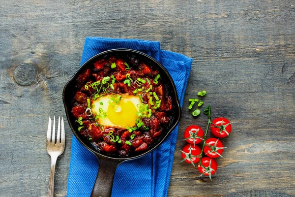Shakshuka dökme demir tavada düz yatıyordu. Yumurta, domates soslu, üstten görünüm. Temiz yemek ve sağlıklı kahvaltı konsepti.