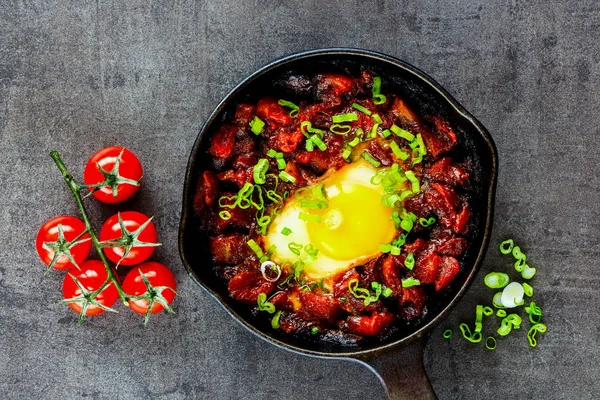 Dökme demir tavada lezzetli shakshuka kapatın. Yumurta, domates soslu, üstten görünüm, lay düz. Temiz yemek ve sağlıklı kahvaltı konsepti. 