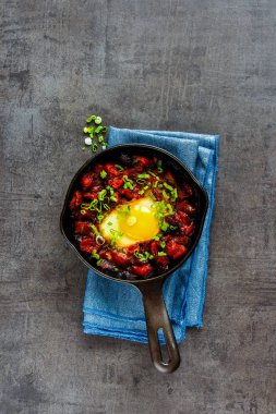 Shakshuka vintage dökme demir tavada - yumurta domates sosu, üstten görünüm, kopya alanı düz-lay. Temiz yemek ve sağlıklı kahvaltı konsepti.