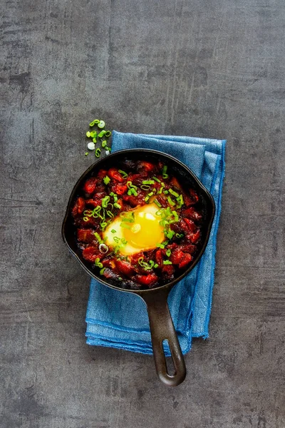 Shakshuka vintage dökme demir tavada - yumurta domates sosu, üstten görünüm, kopya alanı düz-lay. Temiz yemek ve sağlıklı kahvaltı konsepti.