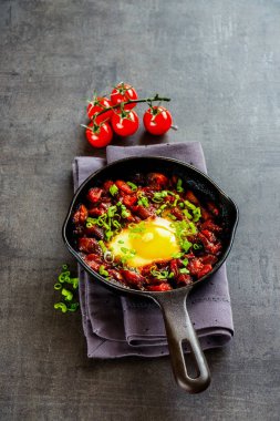 Vejetaryen shakshuka vintage dökme demir tavada - in yumurta domates sosu, yan görünüm, kopya alanı kapat. Temiz yemek ve sağlıklı kahvaltı konsepti.