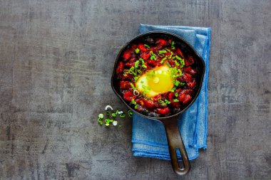 Shakshuka - yumurta domates sosu, üstten görünüm, kopya alanı Vintage dökme demir tava. Temiz yemek ve sağlıklı kahvaltı kavramı. Düz yatıyordu stili.