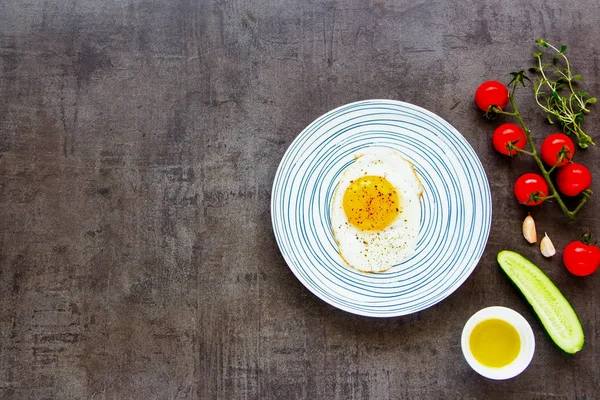 Healthy breakfast and clean eating concept from above. Fried egg in plate on vintage background flat-lay. Healthy food.