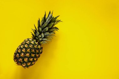 Tropikal meyve ananas sarı arka plan düz üzerinde yatıyordu. Yukarıdan yararlı doğal organik gıda. Bir tüm nesneyi. Stil minimalist.