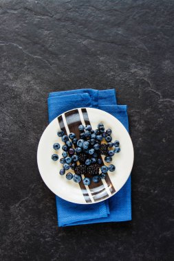 Taze yaban mersini ve blackberry düz lay, organik siyah dut taş zemin, superfood üzerine tabak ve kavram detoks. Üstten görünüm