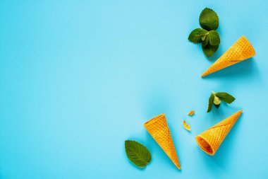 Çerçeve düz-lay gözleme tatlı koni pastel açık mavi renkli taze yaprakları nane ile yapılmış. Tatil ruh kavramı. Bahar ya da yaz kompozisyon ana sayfa görünümü.