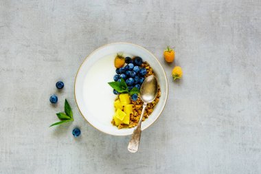 Granola, Yunan yoğurt, taze meyve ve çilek kase masa lambası arka plan üzerinde düz-lay. Temiz yemek, Vejetaryen, Kahvaltı, diyet gıda kavramı. Üstten görünüm