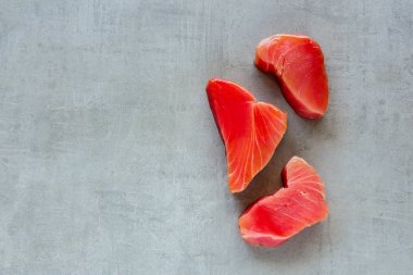 Işık arka plan üzerinde üç ton balığı bifteği. Sağlıklı yemek. Gıda kavramı. Düz yatıyordu, en iyi görünümü