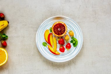 Düz-lay plaka ile tropikal meyve ve taze çilek. Biyo gıda kavramı. Üstten görünüm