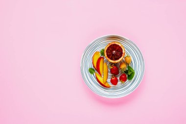 Taze meyve ve çilek pastel pembe arka plan düz üzerinde yatıyordu. Gıda kavramı. Üstten görünüm