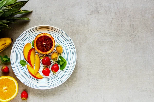 Düz-lay tabak taze tropikal meyve ve organik çilek. Biyo gıda kavramı. Üstten görünüm