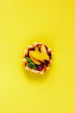 Çikolata ve şeftali sarı arka plan düz-lay ile Belçika waffle