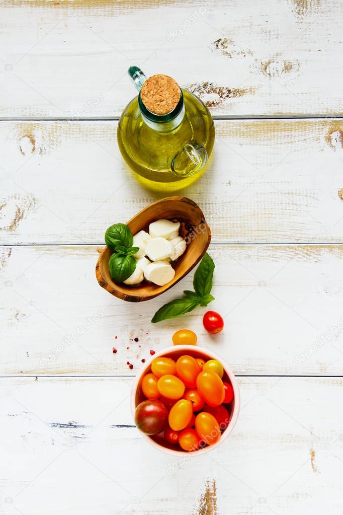 Caprese salad ingredients flat lay. Tomato mozzarella basil leaves and olive oil. Italian cuisine. Mediterranean cuisine.