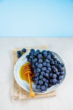 Taze üzüm ve açık renkli tabakta bal