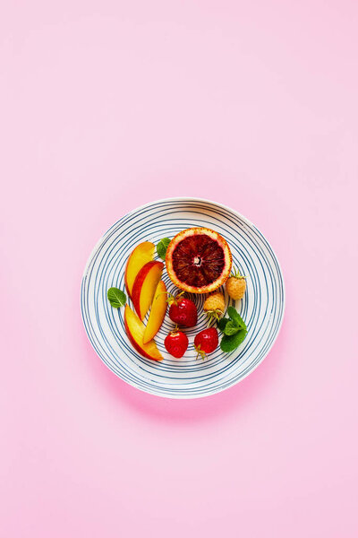 Flat lay of fruits and berries on pastel pink background. Food concept. Top view