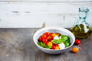 Kase ve malzemeler İtalyan caprese salatası. Domates mozzarella fesleğen yaprakları ve zeytin yağı. İtalyan mutfağı. Akdeniz mutfağı.