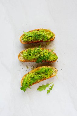 Vegan avokado tost roka düz ile yatıyordu. İyi yağları ham sağlıklı beslenme kavramı.