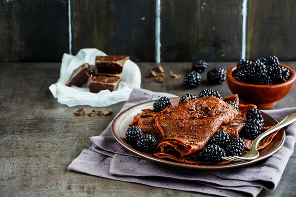 Chocolate thin pancakes, homemade crepes with fresh blackberries