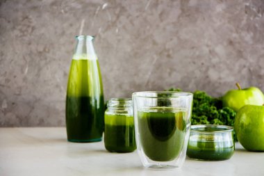Sabah yeşil detoks güler yüzlü veya suyu gözlük, gri arka plan, kopya alanı. Sağlıklı vegan, vejetaryen kahvaltı, mevsimlik detoks, alkali diyet, kilo kaybı gıda kavramı - görüntü