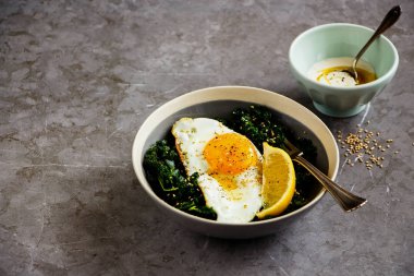 Vejetaryen yemek kase kapatın. Kızarmış yumurta, kale ve susam tohumu ile gri arka plan üzerinde Odaya Servis Kahvaltı. Sağlıklı diyet gıda kavramı - görüntü