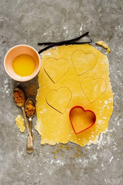 Baking tools and ingredients for cooking cookies-hearts . Flat-lay of raw dought, flour, sugar, vanilla and eggs - Image