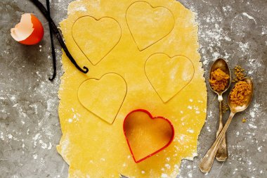 Tanımlama bilgilerini kalpler düz pişirme yatıyordu. Fırın malzemeleri ve araçları. Dought, un, şeker, vanilya ve yumurta kabuğu - görüntü