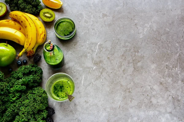 Making green detox smoothie. Fresh ingredients for making smoothie drink over grey concrete background flat lay - Image