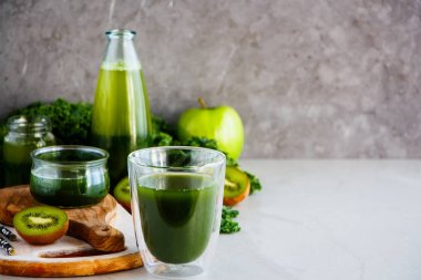 Lezzetli sabah yeşil vegan güler yüzlü veya suyu içinde gözlük, gri arka plan, kopyalama alanı. Sağlıklı vejetaryen kahvaltı, mevsimlik detoks, alkali diyet, kilo kaybı gıda kavramı - görüntü