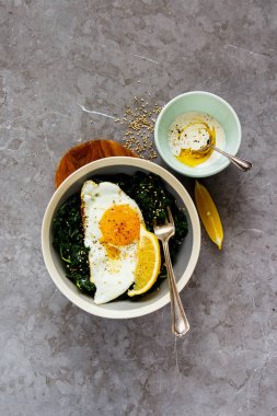 Vejetaryen yemek kase. Düz gri taş zemin, üstten görünüm üzerine kızarmış yumurta, kale ve susam tohumu kahvaltı yatırın. Sağlıklı diyet gıda kavramı - görüntü