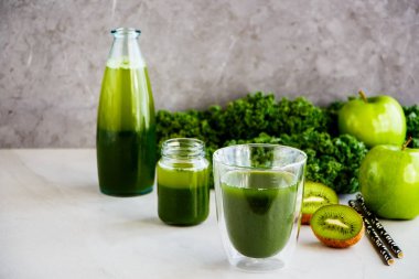 Lezzetli sabah yeşil detoks güler yüzlü veya suyu gözlük, gri arka plan, kopya alanı. Sağlıklı vegan, vejetaryen kahvaltı, mevsimlik detoks, alkali diyet, kilo kaybı gıda kavramı - görüntü