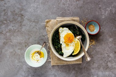 Vejetaryen yemek kase. Düz-lay gri arka plan, üstten görünüm üzerinde kızarmış yumurta, kale ve susam tohumu ile kahvaltı. Sağlıklı diyet gıda kavramı - görüntü
