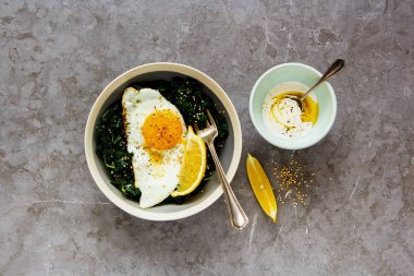 Vejetaryen yemek kase düz-lay. Kızarmış yumurta, kale ve susam tohumu ile gri arka plan üzerinde üstten görünüm Odaya Servis Kahvaltı. Sağlıklı diyet gıda kavramı - görüntü