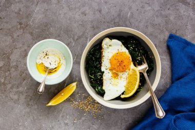 Vejetaryen yemek kase. Kahvaltı kale, kızarmış yumurta ve susam gri arka plan, üstten görünüm üzerinde düz-lay. Sağlıklı diyet gıda kavramı - görüntü