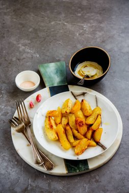 Sarımsak, tuz ve beyaz sos ile kızarmış patates dilimleri, gri beton tablo arka plan - görüntü üzerinde yakın çekim