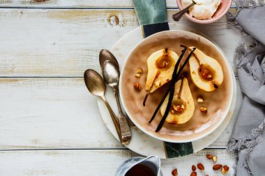Düz-lay lezzetli tatlı armut, badem, akçaağaç şurubu ve vanilya Beyaz ahşap zemin üzerinde pişmiş. Üstten Görünüm - görüntü