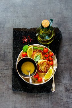 Düz ev yapımı vejetaryen karnabahar kek sos ve taze sebze üstten görünüm ile yatıyordu