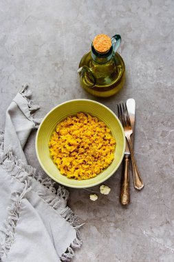 Kabın içinde baharatlar ile lezzetli karnabahar pirinç ve gri beton tablo arka plan üzerinde ham karnabahar düz yatıyordu, en iyi görünümü - görüntü