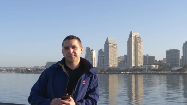 Young man looks at camera and smiles on San Diego — Stock Video