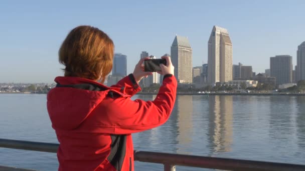 Молодая женщина фотографирует с помощью смартфона — стоковое видео